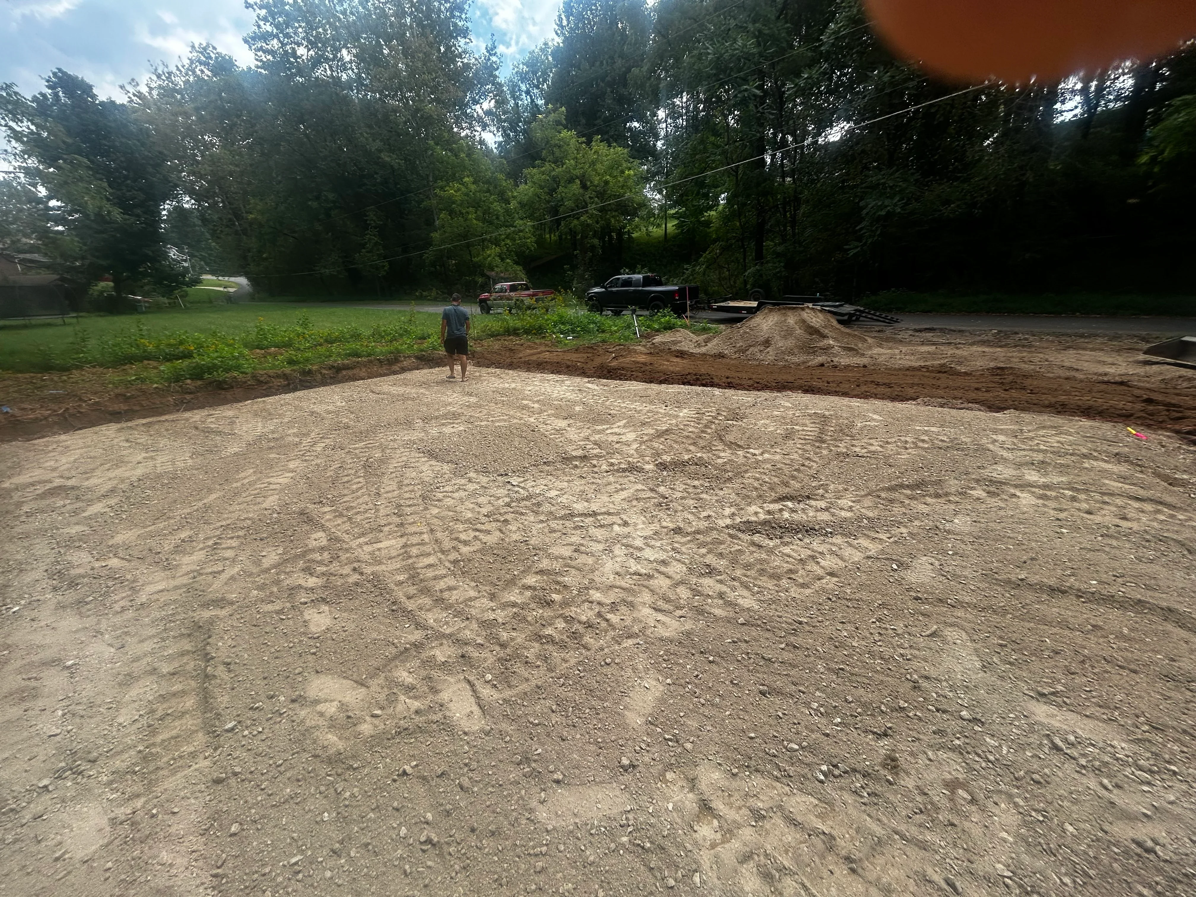 Excavated septic system site with compacted gravel base and cleared work area