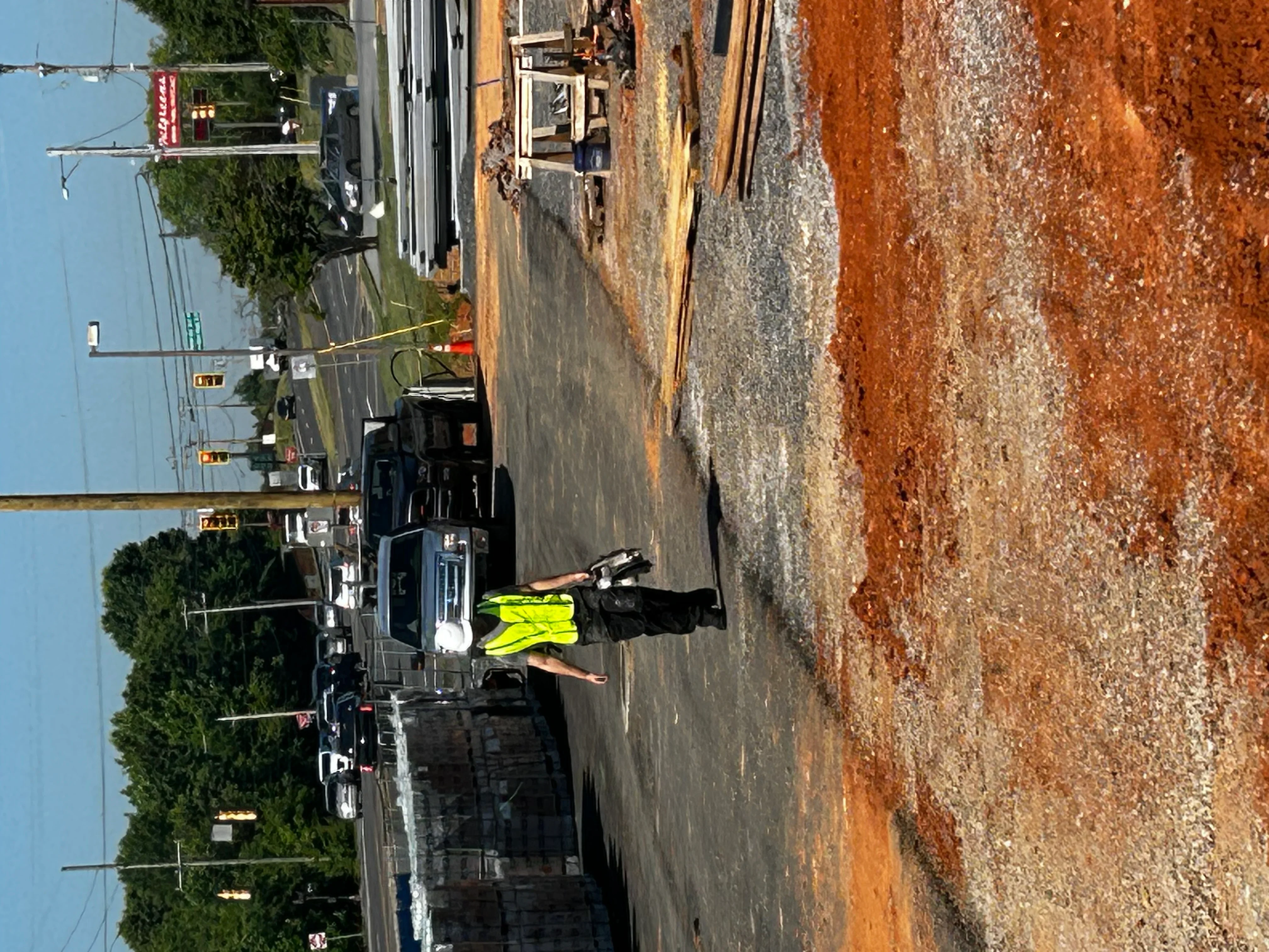 Technician in safety vest inspecting septic tank access point on residential property
