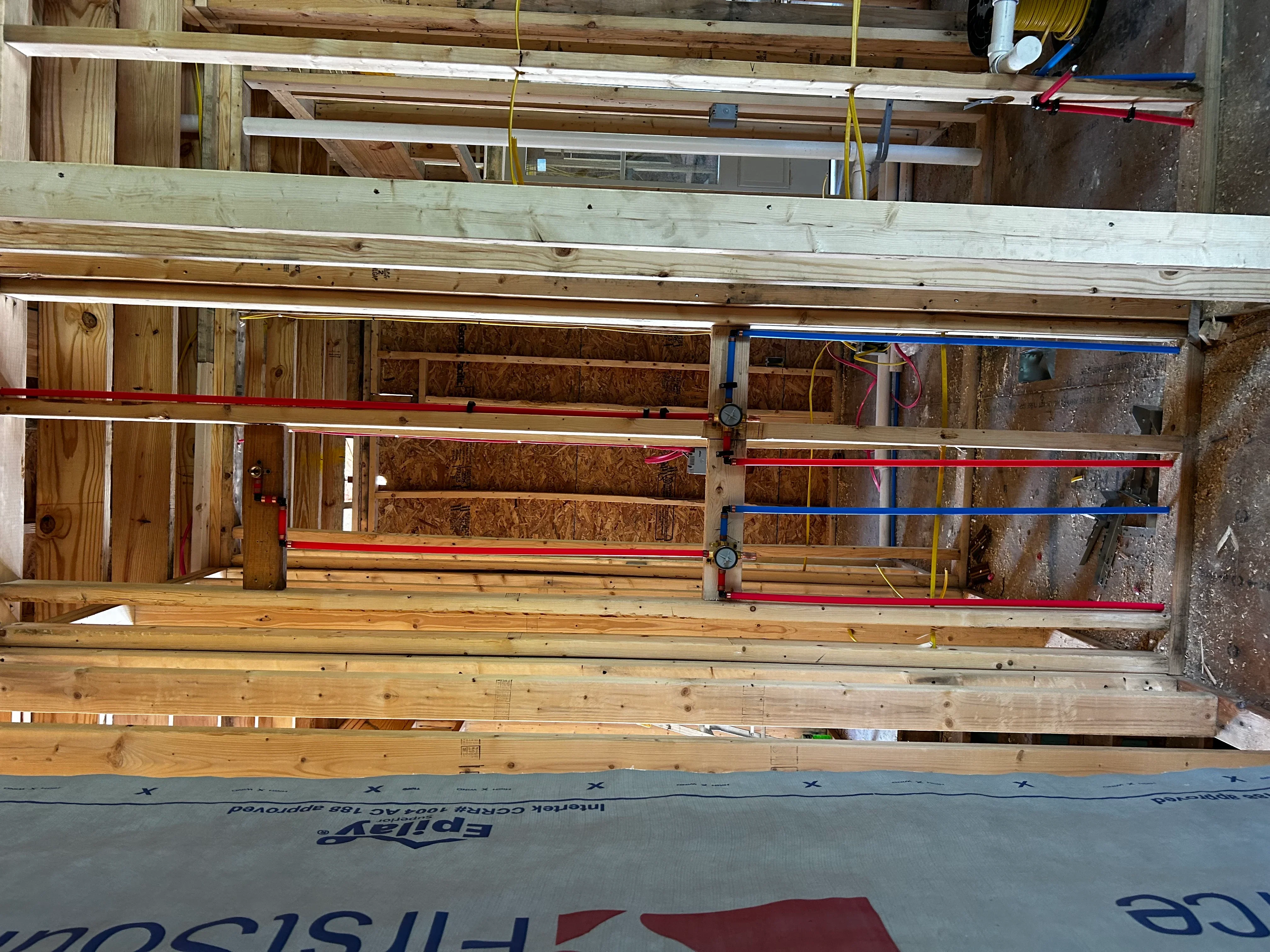 Engineered lumber beams, OSB sheathing, and structural framing with level indicators during residential construction