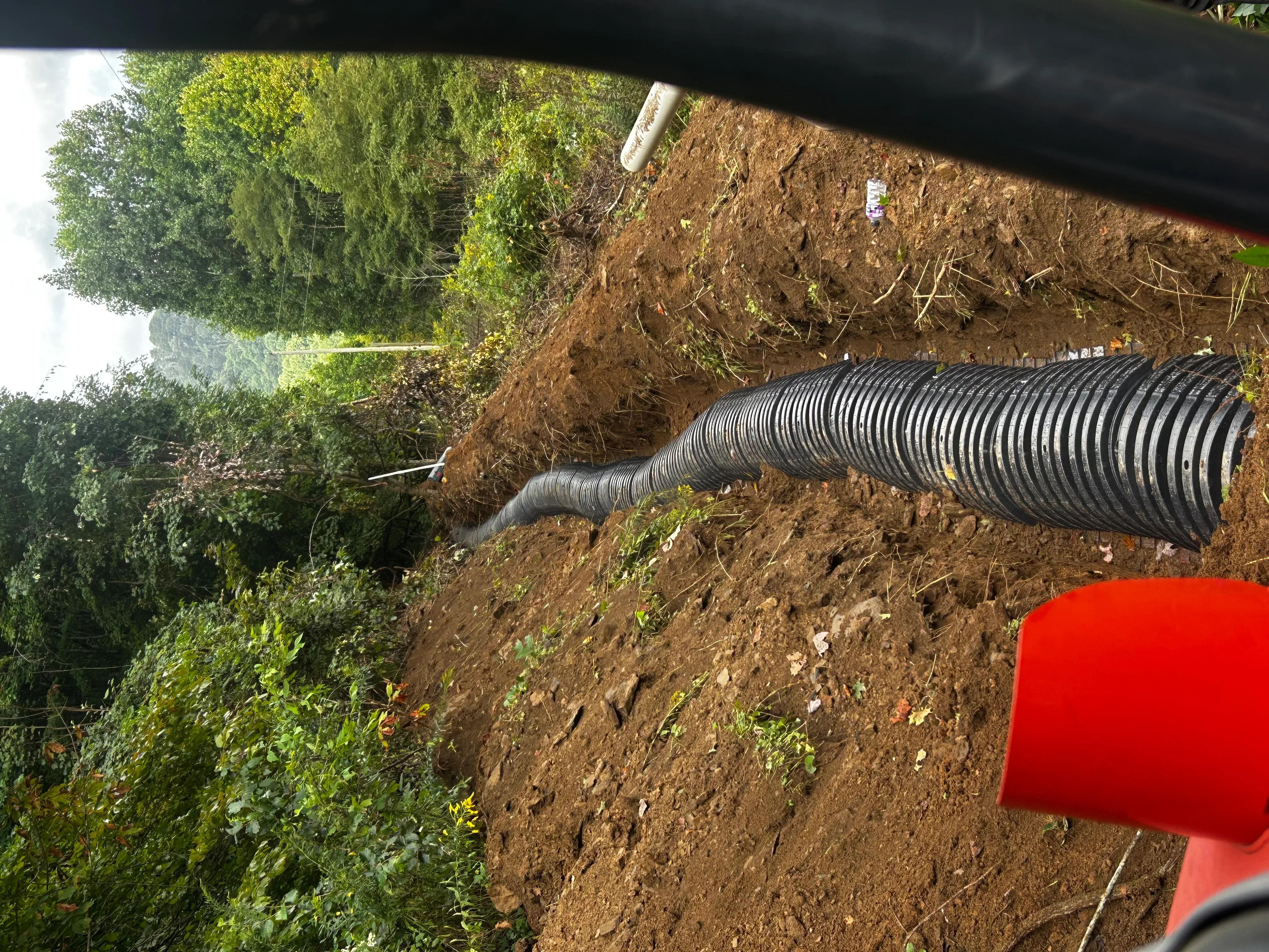 Corrugated septic drainage pipes installed in excavated trench with soil backfill