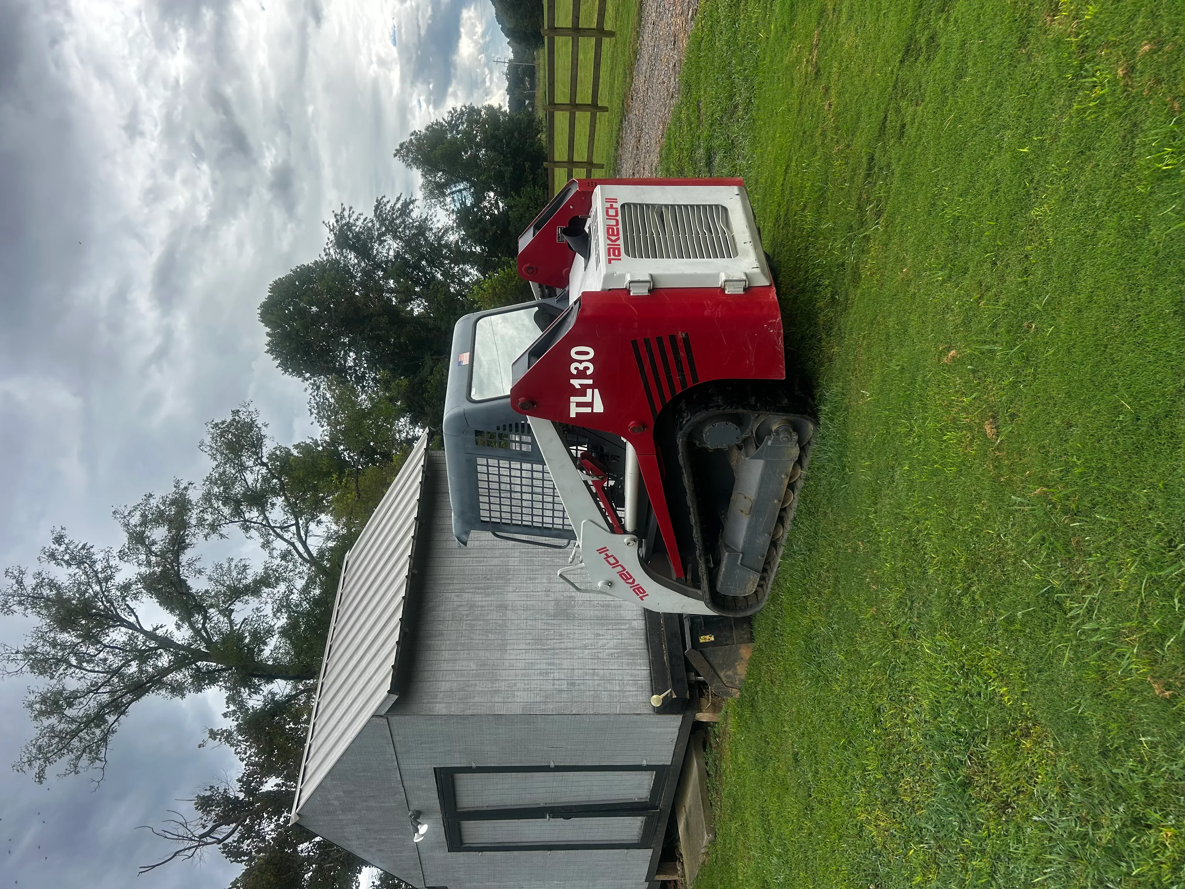 Red and white septic pump truck on residential property with green lawn