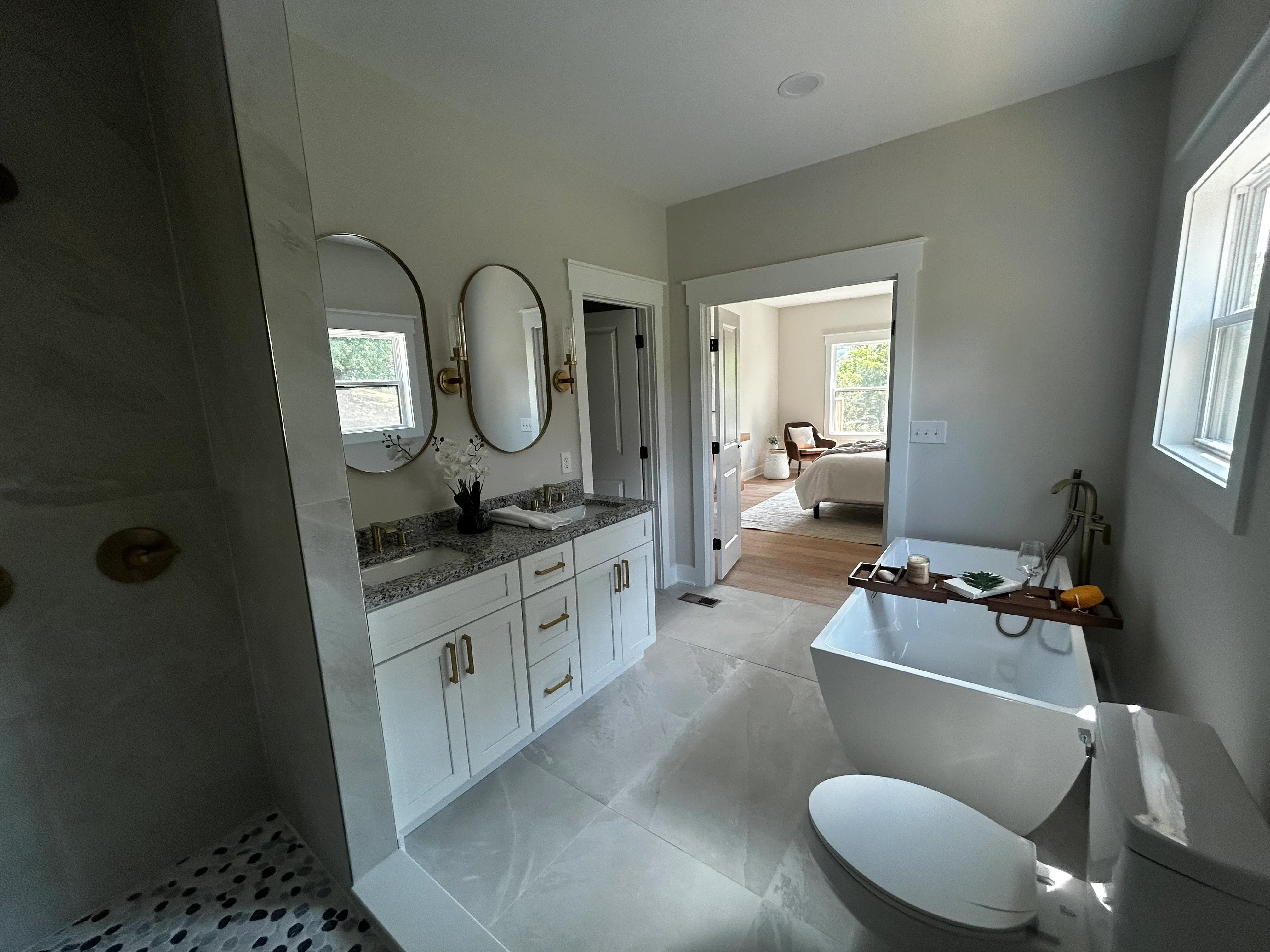 Primary bathroom with dual vanity, freestanding tub, walk-in shower, and polished concrete floors