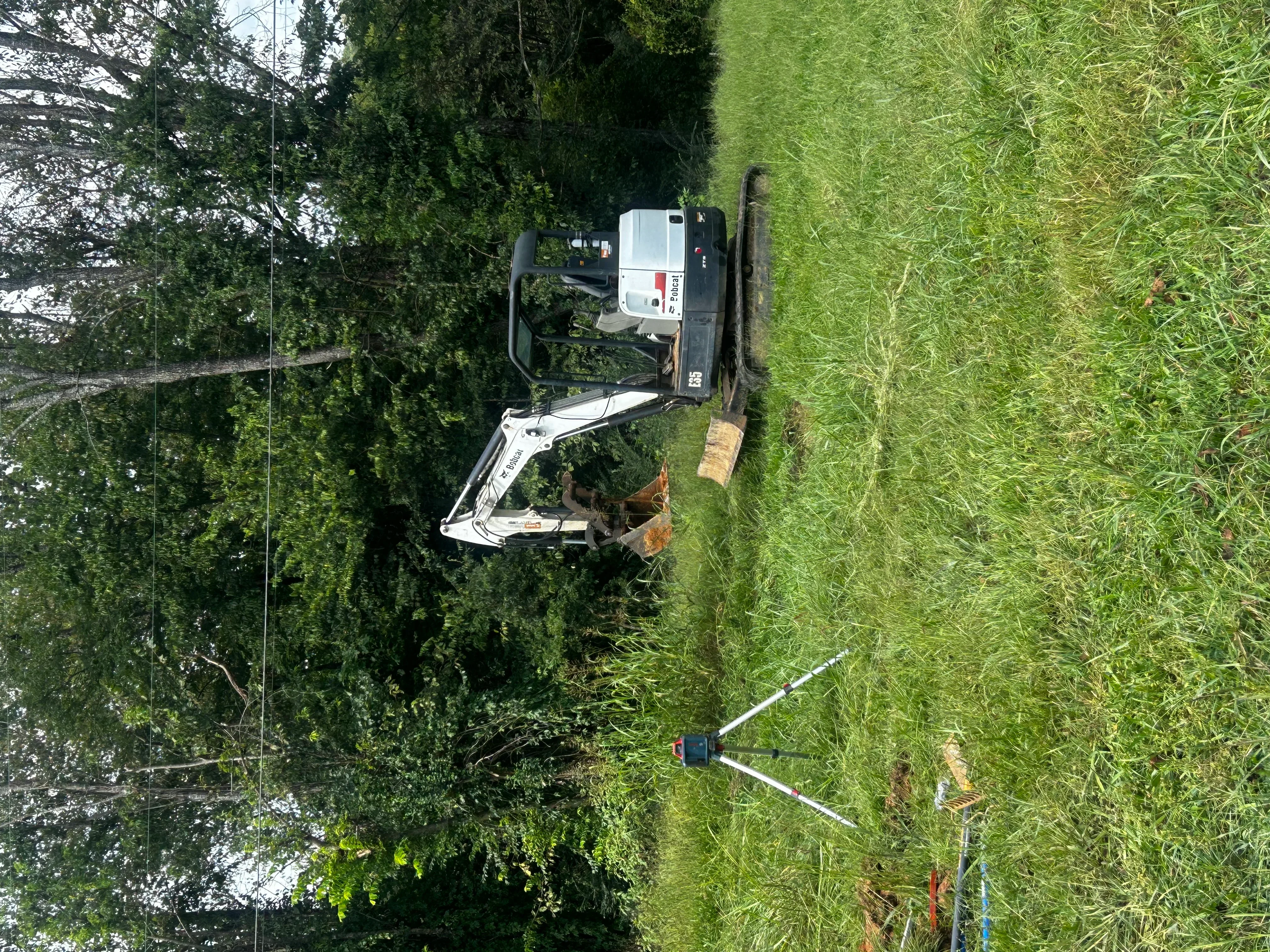 Compact track loader and excavation equipment on residential lawn during septic system service