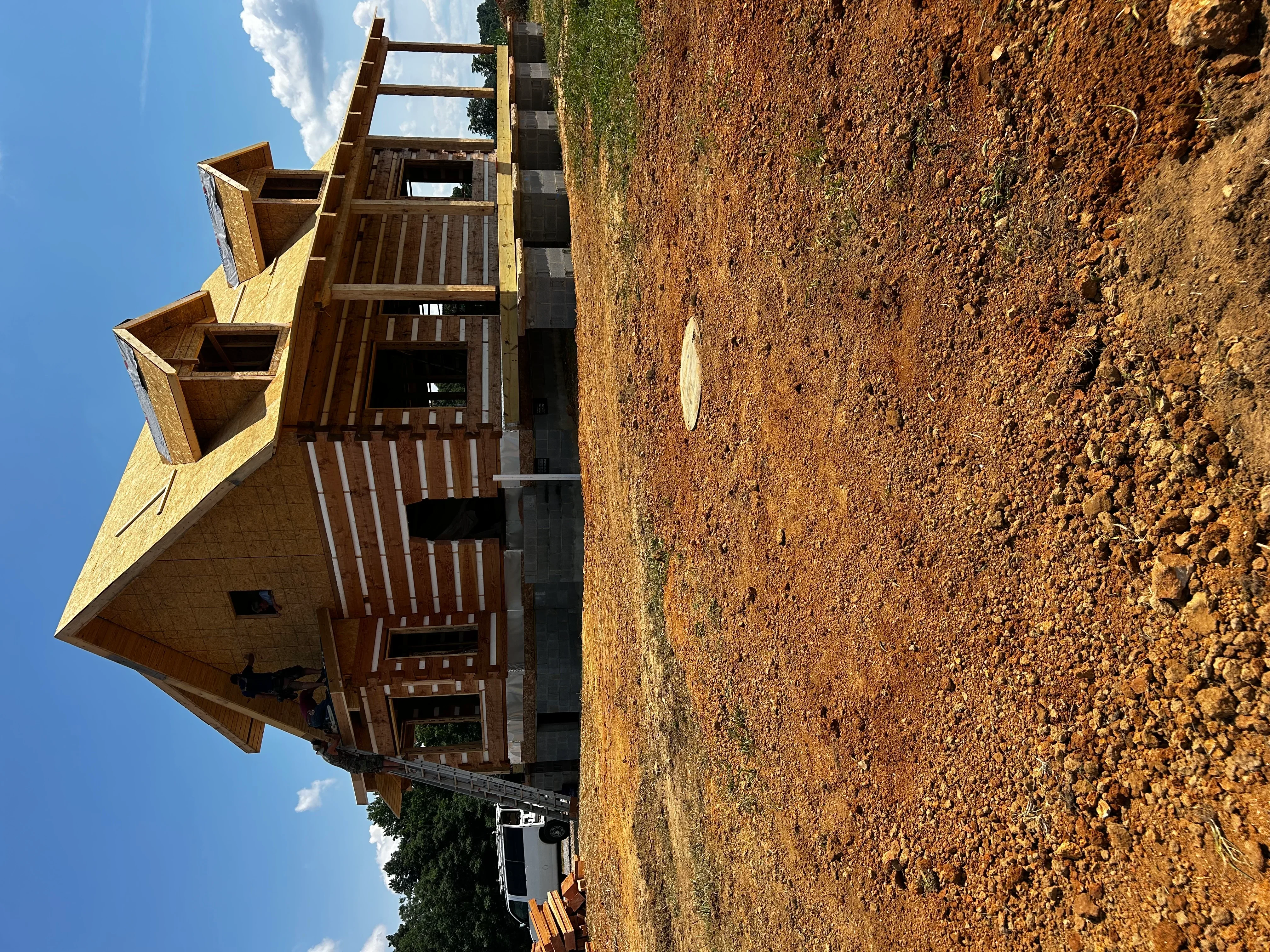 Septic tank installation with brick construction, concrete blocks, wooden access frame, and excavated soil base